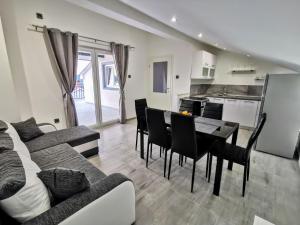 uma sala de estar com mesa e cadeiras e uma cozinha em Apartmani Krnić em Sibenik