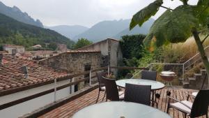 a balcony with a table and chairs and mountains at La Maison in Axat