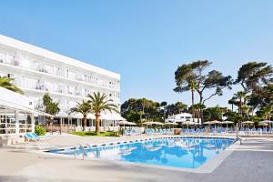 a hotel with a swimming pool in front of a building at Globales Cala Blanca in Cala Blanca