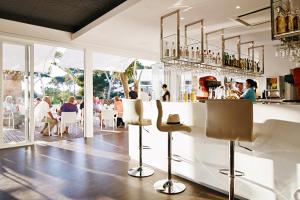 a bar in a restaurant with people sitting at tables at Globales Cala Blanca in Cala Blanca