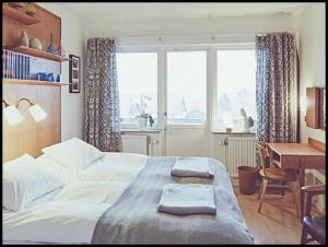 Schlafzimmer mit einem Bett, einem Schreibtisch und einem Fenster in der Unterkunft Hotell Hanöbris på Kivik in Kivik