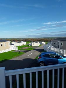 a blue car parked on the balcony of a house at Clearwater lodge Widemouth sands in Poundstock