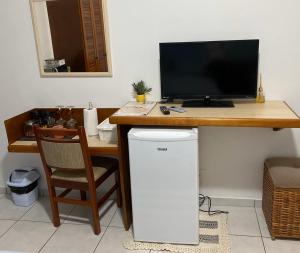 uma secretária com um computador e um monitor em cima em Amarilis Flat Service em Rivera de São Lourenço