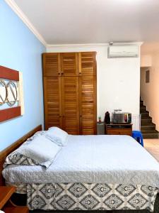 um quarto com uma cama e um armário de madeira em Amarilis Flat Service em Riviera de São Lourenço