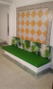 un divano verde in una stanza con parete di HOTEL CASA GARCES a Cartagena de Indias