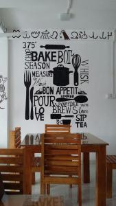 a dining room with a table and a wall with writing on it at The Finz in Hikkaduwa