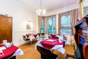 a dining room with two tables and a piano at St Marys Guest House in York