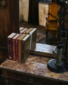 a pile of books sitting on a table in front of a mirror at The Mustang Blu in Bangkok