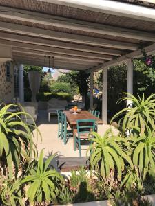 eine Terrasse mit einem Tisch und Stühlen unter einer Pergola in der Unterkunft Casa Viansa in Favignana