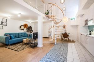 ブダペストにあるROOMLI Boho Chic Apartmentsの青いソファとキッチンのあるリビングルーム