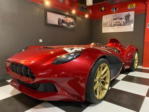 カンヌ・エクリューズにあるEnzo Hotels Cannes-Écluse by Kyriad Directの赤い車が部屋に展示されています