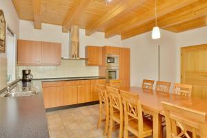 a large kitchen with a wooden table and chairs at Chalupa FRED s infra saunou in Vrchlabí
