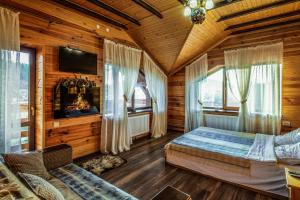 a bedroom in a log cabin with a bed and windows at Cottage Chalet-Tiara in Slavske