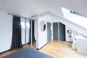 a room with white walls and a staircase with mirrors at Sweet Home Rennes Centre Historique 65 m2 in Rennes