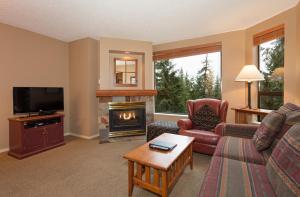 a living room with a couch and a fireplace at The Marquise by Whistler Premier in Whistler