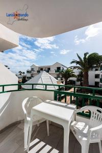 two white chairs and a table on a balcony at Vivienda Vacacional Buby in Costa Teguise
