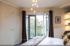 a bedroom with a bed and a sliding glass door at Neon Melody - Playful 2 Bedrooms by London Bridge in London