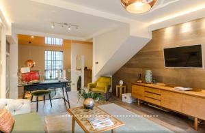 a living room with a couch and a tv at Neon Melody - Playful 2 Bedrooms by London Bridge in London