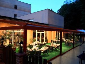 a restaurant with tables and chairs on a patio at Hotel Sudety in Głuchołazy