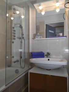 a white bathroom with a sink and a shower at Studio climatisé 1 à 4 personnes vue mer in Le Grau-du-Roi