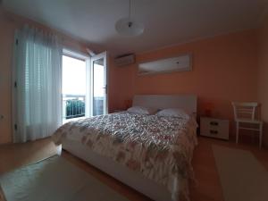 a bedroom with a bed and a large window at Dražen Apartment in Orebić