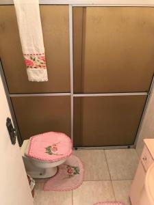 a bathroom with a shower with a toilet and towels at Acomodação central e WI-FI in São Lourenço do Sul