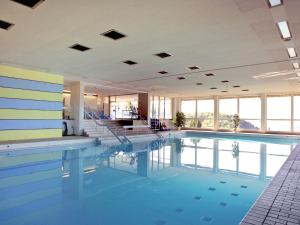 a large swimming pool in a building with windows at Hotel Bad Ramsach in Läufelfingen