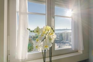 
a white vase filled with flowers on top of a window sill at Lx Boutique Hotel in Lisbon
