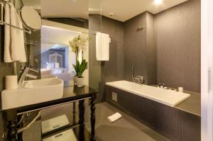 a bathroom with a large white sink and a tub at Lx Boutique Hotel in Lisbon