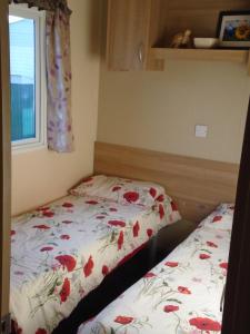 1 dormitorio con 1 cama con colcha de flores en The Pet Friendly Pad en Hunstanton