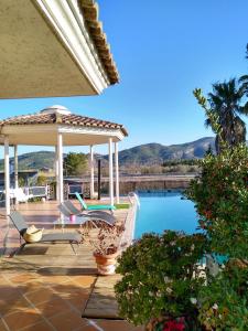 een patio met een prieel en een zwembad bij Villa los Angeles Piscine privée pour 20 personnes in Sant Mateu