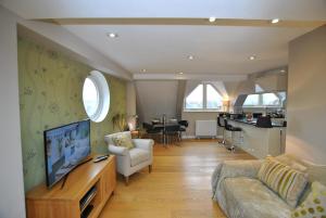 een woonkamer met een bank en een tv en een keuken bij Two Bedroom Apartments in Central Windsor with Parking in Windsor
