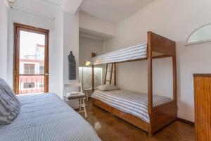 a bedroom with two bunk beds and a window at Apartamento Vintage Frente ao Mar in Monte Gordo