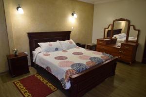 a bedroom with a bed and a dresser and a mirror at Hotel Casa Montero in Quito