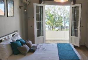 un bambino sdraiato su un letto in una camera da letto con porta aperta di Palmar Beach Villa a Palmar