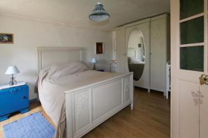 Schlafzimmer mit einem weißen Bett und einem Spiegel in der Unterkunft Gîte Du Cheval De Renfort in Ohis