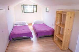 2 łóżka w pokoju z fioletową pościelą w obiekcie House Starfish w mieście Pašman