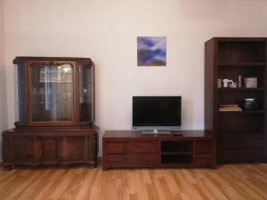 a living room with a tv and a wooden cabinet at Ferienwohnung - Apartment mit Balkon in Halle-Saale, Trotha in Halle an der Saale