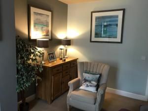 a living room with a chair and a desk at Cosy house set in historic town of Clitheroe in Clitheroe +12 photos