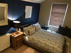 - une chambre avec un lit et un mur bleu dans l'établissement Cosy house set in historic town of Clitheroe, à Clitheroe