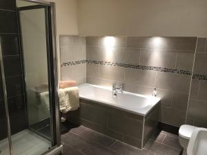 a bathroom with a tub and a shower and a sink at Cosy house set in historic town of Clitheroe in Clitheroe