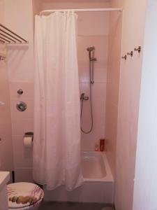 a bathroom with a shower with a white shower curtain at Ferienwohnung - Apartment mit Balkon in Halle-Saale, Trotha in Halle an der Saale