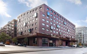 un grande edificio in mattoni all'angolo di una strada di PIERDREI Hotel HafenCity Hamburg ad Amburgo