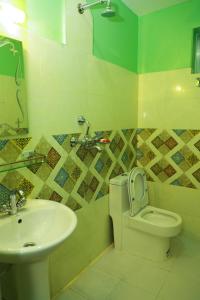 y baño con aseo y lavamanos. en Hotel Pokhara Paradise, en Pokhara