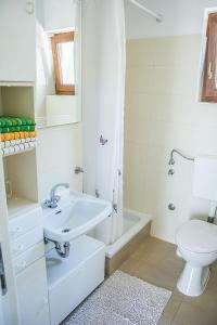 a white bathroom with a sink and a toilet at House Divna in Kraj