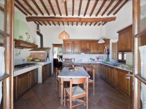 a kitchen with wooden cabinets and a table with chairs at Tenuta La Silva in Seggiano