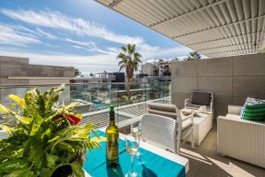 uma varanda com uma mesa com copos de vinho em Carmencita Studio B14 with pool & gym em Limassol