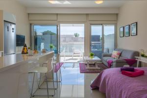 uma cozinha e sala de estar com um sofá e uma mesa em Carmencita Studio B14 with pool & gym em Limassol