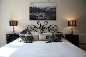ケンダルにあるLuxury riverside apartment in Kendalのベッドルーム(白い大型ベッド、ランプ2つ付)