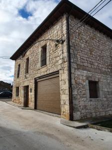 um grande edifício de tijolos com garagem em Casa rural Los Bodones em Quintanilla Riopico